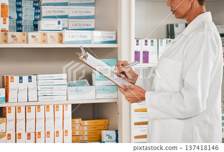 Woman, pharmacist and writing on clipboard for inventory inspection on pills, tablets or medication on shelf at pharmacy. Female person or medical worker checking stock or pharmaceutical at drugstore Woman, pharmacist and writing on clipboard for inventory inspection on pills, tablets or medication on shelf at pharmacy. Female person or medical worker checking stock or pharmaceutical at drugstore 137418146