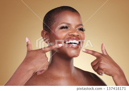Teeth, beauty and a woman pointing at smile in studio for skin care, glow or cosmetics. Face of African model person with dental shine, dermatology and makeup announcement on a beige background Teeth, beauty and a woman pointing at smile in studio for skin care, glow or cosmetics. Face of African model person with dental shine, dermatology and makeup announcement on a beige background 137418171