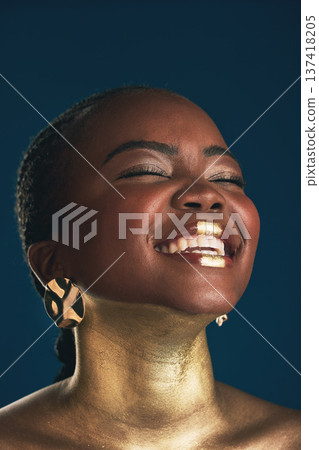 Gold makeup, face and black woman laughing at funny creativity, facial cosmetics paint and beauty art design. African culture joke, comedy or glamour person with creative face glow on blue background Gold makeup, face and black woman laughing at funny creativity, facial cosmetics paint and beauty art design. African culture joke, comedy or glamour person with creative face glow on blue background 137418205