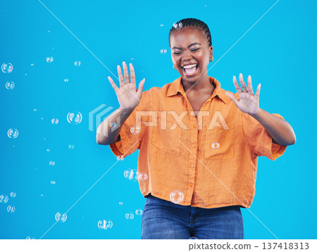 Excited, laugh and black woman on blue background with bubbles for happiness, joy and have fun. Playful, happy smile and isolated African person in studio with soap bubble for freedom and color Excited, laugh and black woman on blue background with bubbles for happiness, joy and have fun. Playful, happy smile and isolated African person in studio with soap bubble for freedom and color 137418313