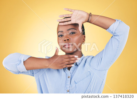 Hands, frame and portrait of African woman in studio for confidence, creativity and beauty. Photography, perspective and face of serious person on yellow background with cosmetics, makeup and glamour Hands, frame and portrait of African woman in studio for confidence, creativity and beauty. Photography, perspective and face of serious person on yellow background with cosmetics, makeup and glamour 137418320