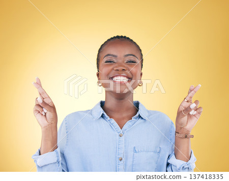 Wish sign, fingers crossed and portrait of black woman in studio smile for hope, winning and success. Emoji, excited and face of African person on yellow background with hand gesture for miracle Wish sign, fingers crossed and portrait of black woman in studio smile for hope, winning and success. Emoji, excited and face of African person on yellow background with hand gesture for miracle 137418335
