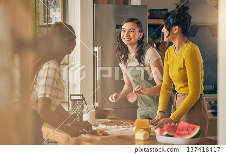 Happy, friends and women cooking pizza in kitchen, bonding and having fun together in home. Smile, girls and baking food, margherita and salami bread at lunch, cheese on meat and watermelon at brunch Happy, friends and women cooking pizza in kitchen, bonding and having fun together in home. Smile, girls and baking food, margherita and salami bread at lunch, cheese on meat and watermelon at brunch 137418417