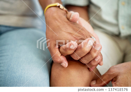 Love, support and couple holding hands for bonding, unity and connection in the living room of their home. Empathy, closeup and people with affection moment for sympathy after loss, sadness or grief. 137418576