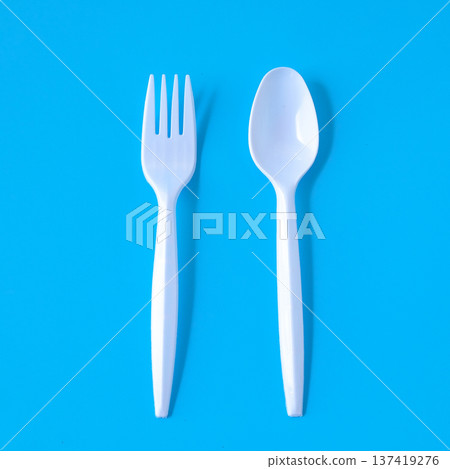 white plastic fork and spoon on color background. white plastic fork and spoon on color background. 137419276