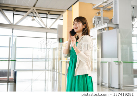 一位女士在機場打電話。照片由關西國際機場(KIX)提供。 一位女士在機場打電話。照片由關西國際機場(KIX)提供。 137419291
