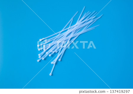 white nylon cable ties on color background. 137419297