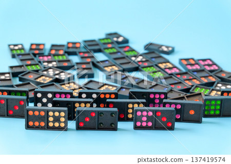 Black domino tiles on color background.Domino effect. 137419574