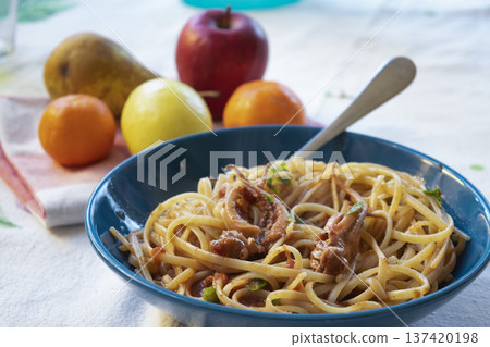 spaghetti with squid ragu sauce in blue dish with fresh fruit on the background 137420198