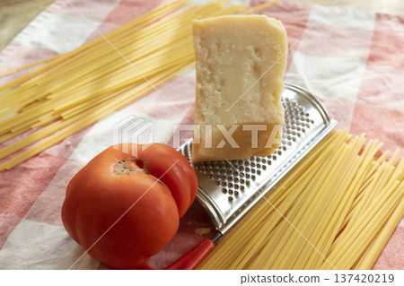 ingredients spaghetti to prepare with parmigiano,  and a big tomato 137420219