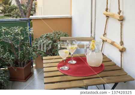fresh lemonade in pitcher with glasses on an outdoor patio table 137420325