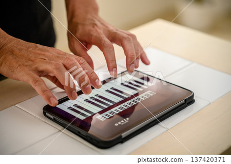 Playing piano on a tablet Playing piano on a tablet 137420371