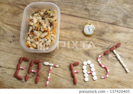 eat fast message with pills and half plate of food on table eat fast message with pills and half plate of food on table 137420405