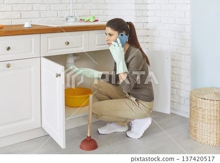 Upset Woman Calling Plumber For Sink Clog 137420517