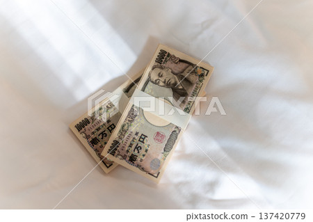 床上放著兩疊日元鈔票 137420779