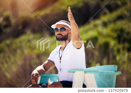 Summer, sports and a volleyball referee on the beach in a chair for authority, rules or regulations during a game. Health, professional or competition with a man refereeing a match outdoor in the day Summer, sports and a volleyball referee on the beach in a chair for authority, rules or regulations during a game. Health, professional or competition with a man refereeing a match outdoor in the day 137420978