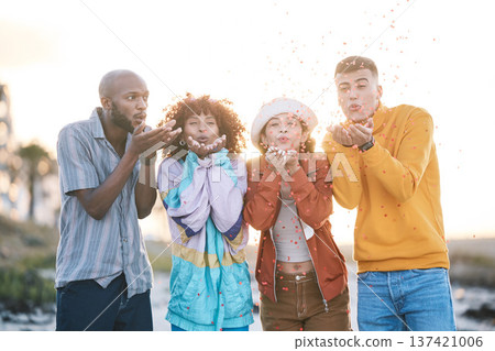 Friends, outdoor and people blowing confetti outdoor for celebration, motivation and fun. Diversity, happiness and group of men and women for adventure, party and happy youth with freedom in nature 137421006