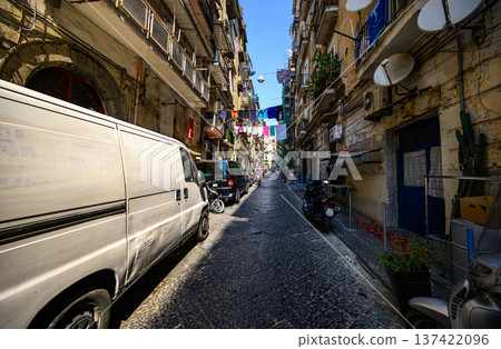 Historic street scene in Naples, Italy featuring narrow architecture, traditional residential buildings and stone pavement typical of southern Italian cities. Historic street scene in Naples, Italy featuring narrow architecture, traditional residential buildings and stone pavement typical of southern Italian cities. 137422096