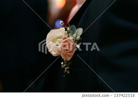 Groom at a wedding with a boutonniere of white gypsophila and rose 137422518