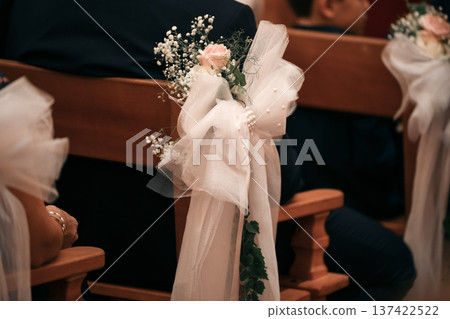 Closeup of tulle bow with roses on wedding church wooden pew 137422522