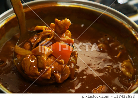 Scooping up pork curry from a hot pot 137422658