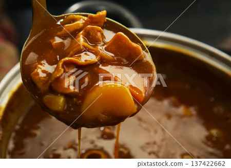 Scooping up pork curry from a hot pot 137422662