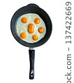 A giant double yolk egg omelette sits in a black frying pan. The pan is placed on a stove in a kitchen. The yolks are bright and noticeable, inviting a hearty meal. 137422669