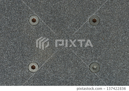 Close view of a skateboard deck with grip tape and screws 137422836