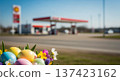 Easter eggs flowers by roadside gasstation, spring pastel travel holiday scene with copyspace for seasonal service ads 137423162