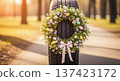 Tire with Easter wreath of flowers and pastel eggs on road outdoors. Spring auto service display, seasonal transport decor, holiday promotion, roadside retail, sunny park. 137423172