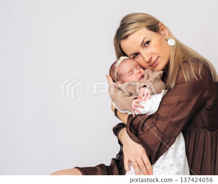 Studio portrait of young mother hugging baby. Ideal image for family, parenting and Mothers Day advertising concepts.  137424056