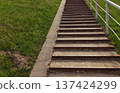 A staircase outdoors with a green field in the background. Journey and peaceful nature atmosphere. 137424299