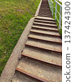 A staircase outdoors with a green field in the background. Journey and peaceful nature atmosphere. 137424300