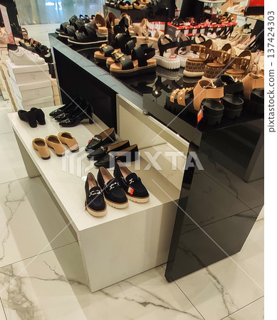 Shelves filled with casual and formal shoes in a retail shop. Stylish designs and contemporary shopping vibe. Shelves filled with casual and formal shoes in a retail shop. Stylish designs and contemporary shopping vibe. 137424303