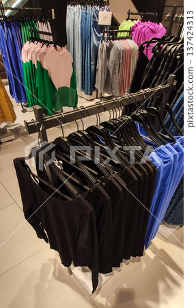 A modern clothing store with racks of stylish apparel. Trendy fashion and curated retail space. A modern clothing store with racks of stylish apparel. Trendy fashion and curated retail space. 137424313