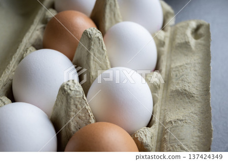 White and brown fresh eggs. Nature background. Chicken egg in carton box for cooking healthy food. Bio organic eggs on the farm. Food concept. 137424349