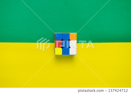 Colorful Puzzle Cube on Vibrant Green and Yellow Background Colorful Puzzle Cube on Vibrant Green and Yellow Background 137424712