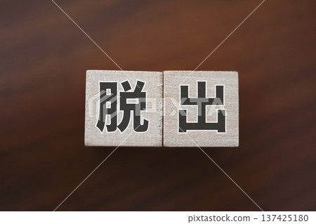木質背景上點綴著代表「逃脫」的字母方塊。 木質背景上點綴著代表「逃脫」的字母方塊。 137425180