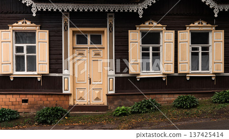 Traditional Wooden House Facade with Ornate Windows and Door Traditional Wooden House Facade with Ornate Windows and Door 137425414