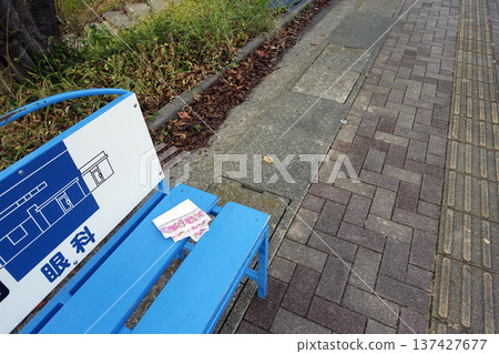 公車站藍色長椅上遺落一條白色手帕。 公車站藍色長椅上遺落一條白色手帕。 137427677