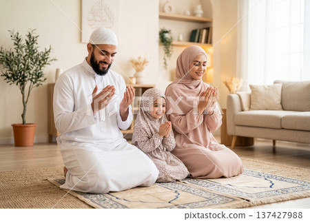 Muslim family praying together at home on prayer mats 137427988