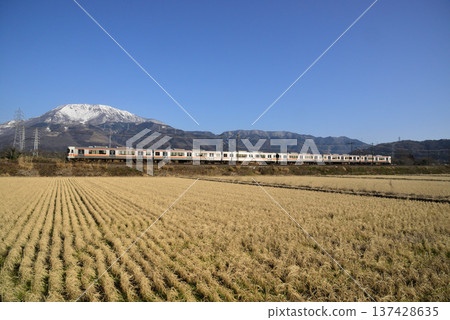 JR Central 313 series train running under a clear blue sky with snow-covered Mt. Ibuki in the background 137428635