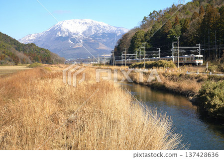 JR東海313系列車在湛藍的天空下行駛，背景是白雪皚皚的伊吹山。 137428636