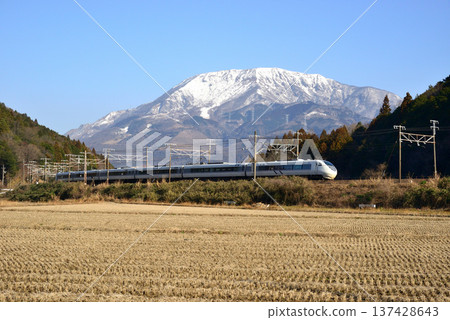 JR Central Shirasagi train running under a clear blue sky with snow-capped Mt. Ibuki in the background 137428643