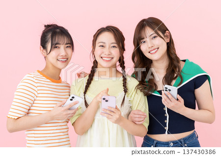 Young women with smartphones Young women with smartphones 137430386