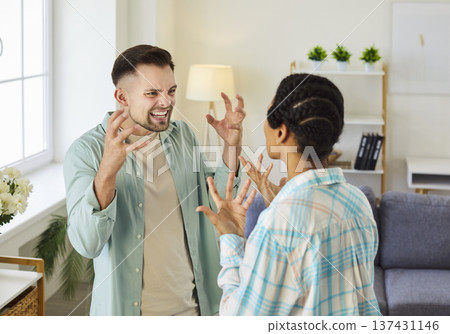 Young couple man and woman standing at home and arguing shouting in quarrel. 137431146