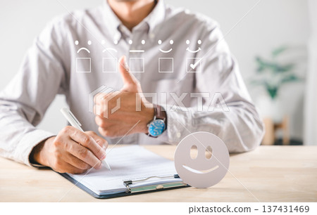 Satisfaction customer survey feedback shows excellent service review, person gives enthusiastic thumbs up, completes evaluation form, selects best emoji rating for positive experience, happy smiley Satisfaction customer survey feedback shows excellent service review, person gives enthusiastic thumbs up, completes evaluation form, selects best emoji rating for positive experience, happy smiley 137431469