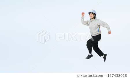 Full-body photo of a woman in work clothes jumping Full-body photo of a woman in work clothes jumping 137432018