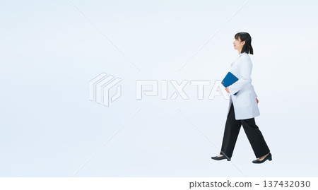 Full-body photo of a walking woman in a white coat Full-body photo of a walking woman in a white coat 137432030