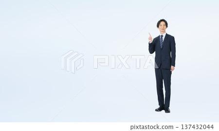 Full-body photo of a male business person in a suit pointing 137432044